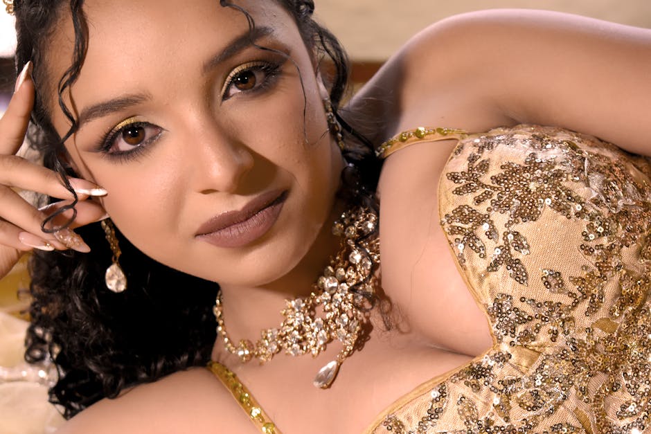 Close-up portrait of a woman in a gold embellished gown, exuding elegance and style.