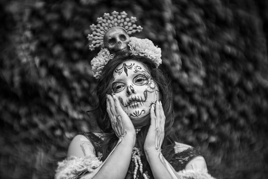 Black and white portrait of a woman in Catrina makeup for Day of the Dead celebration.