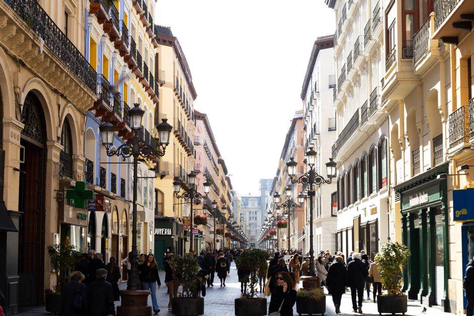 Crowded pedestrian street in Zaragoza, Spain, showcasing vibrant city life and architecture.