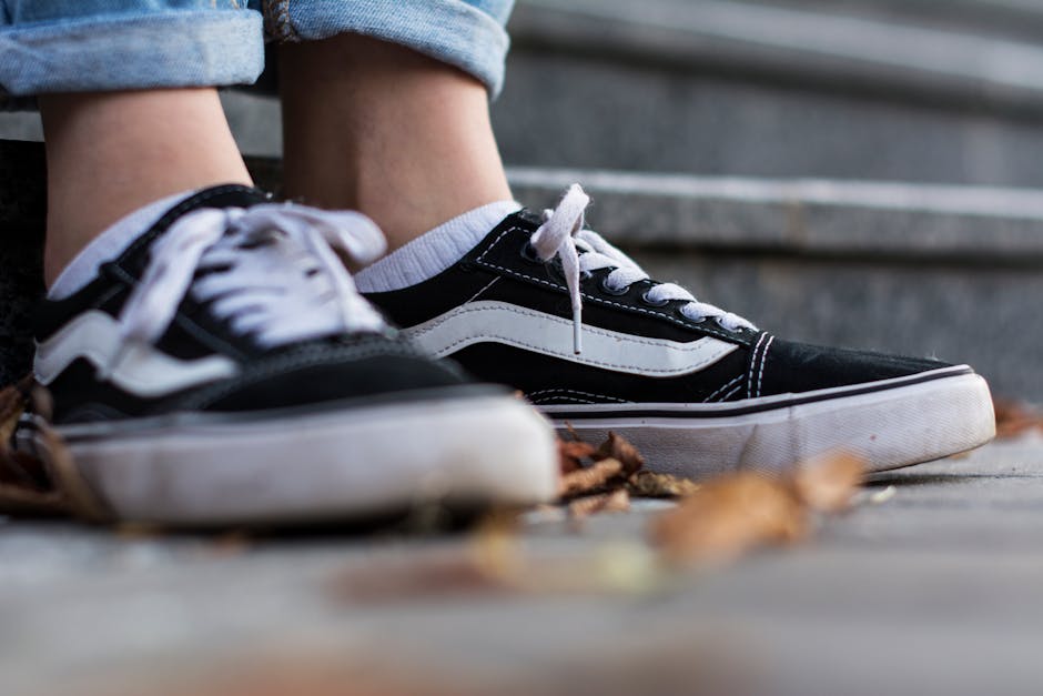 A close-up of black and white sneakers on stone steps, symbolizing casual style and comfort.