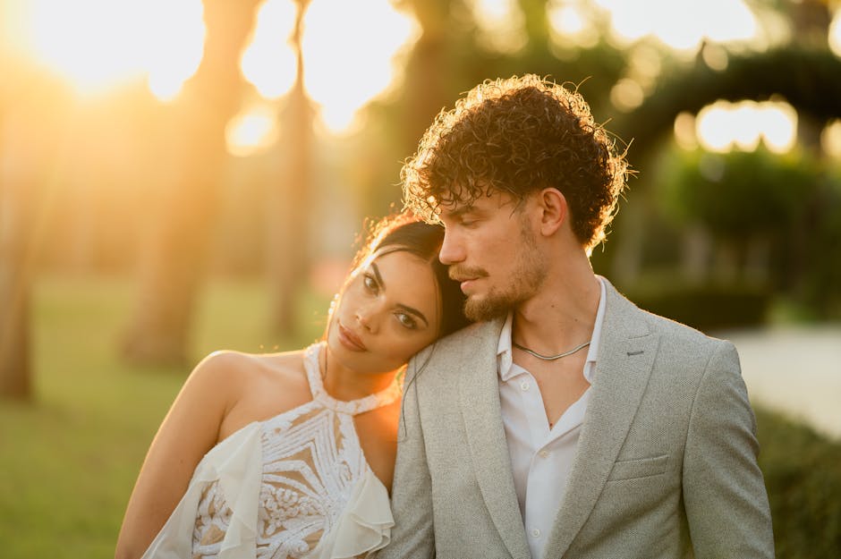 A romantic couple enjoying a tender moment outdoors in the warm sunset glow.