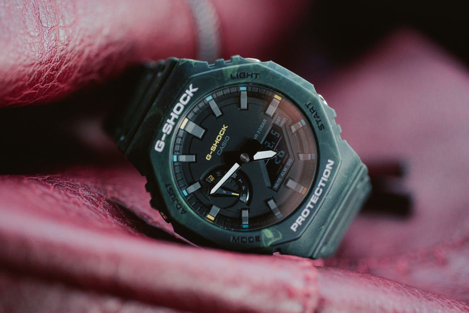 Close-up of a G-SHOCK digital wristwatch displayed on red leather.